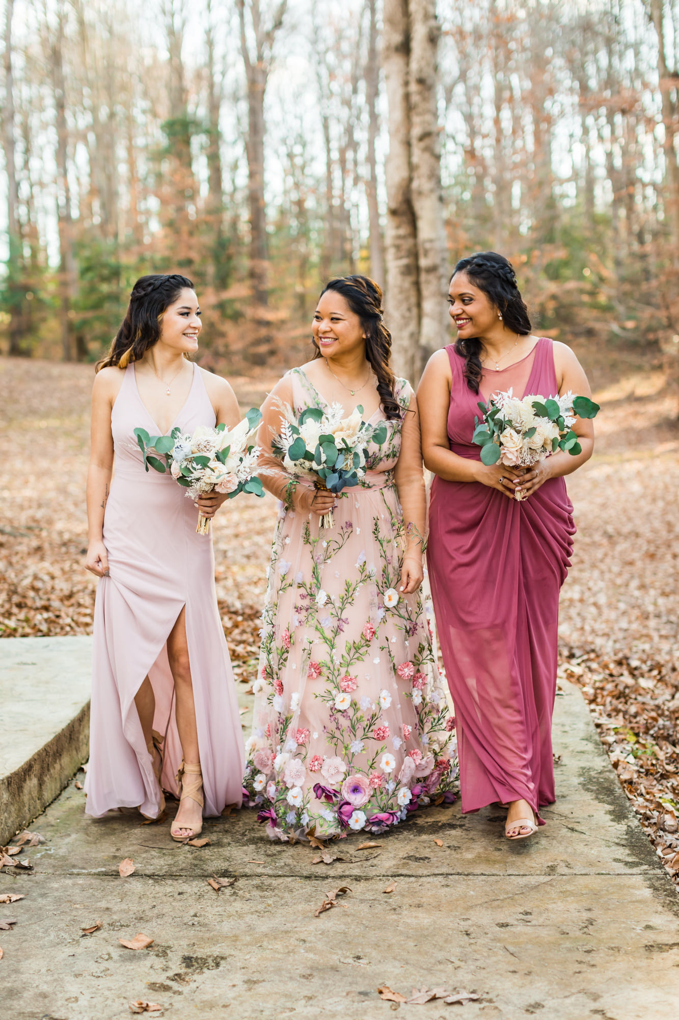 bride walking with bridesmaids wearing pink gowns