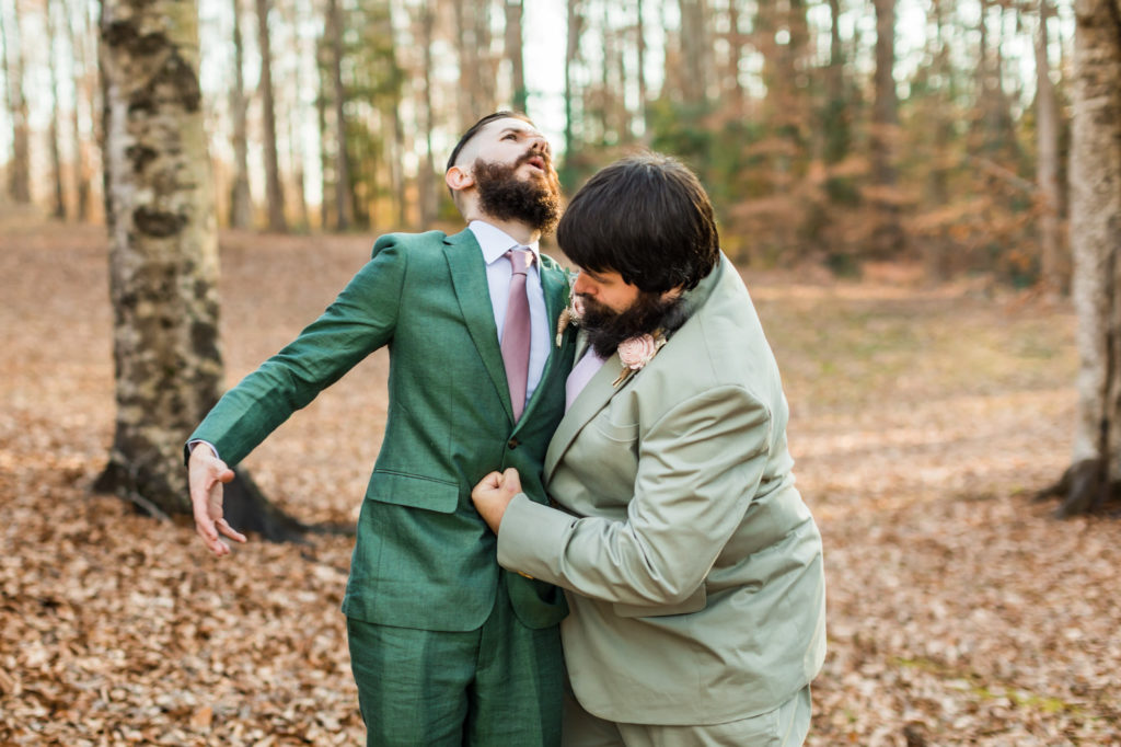 groom chest bumping groomsmen in green wedding attire