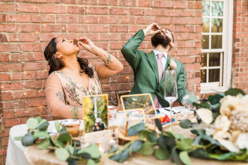 wedding couple taking shots together during woodland chic reception