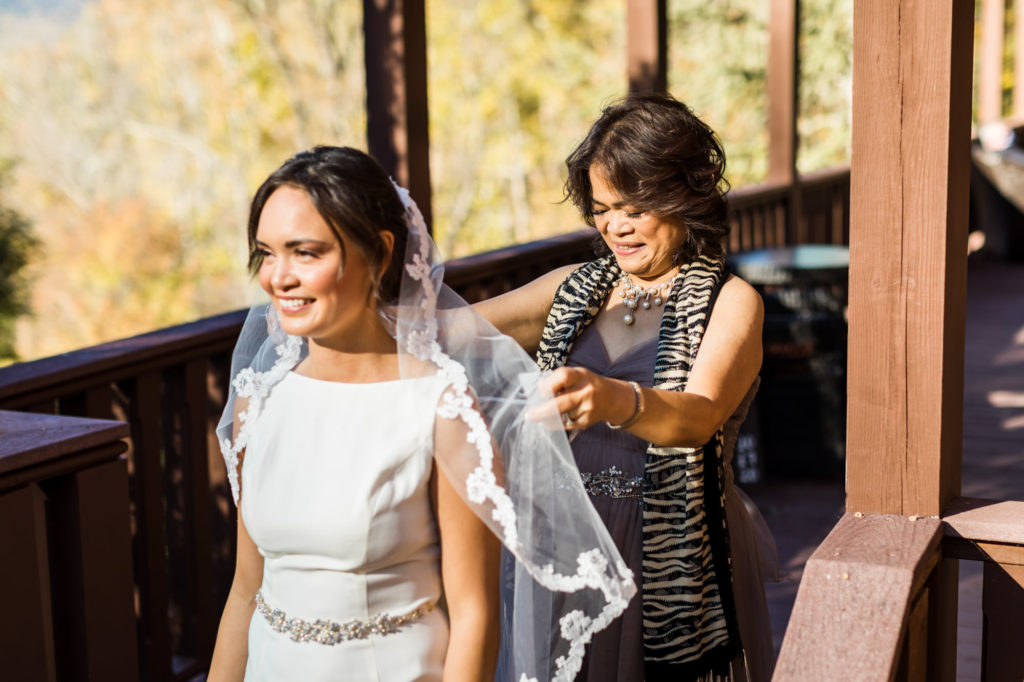 bride getting ready to walk down aisle as mother fluffs veil