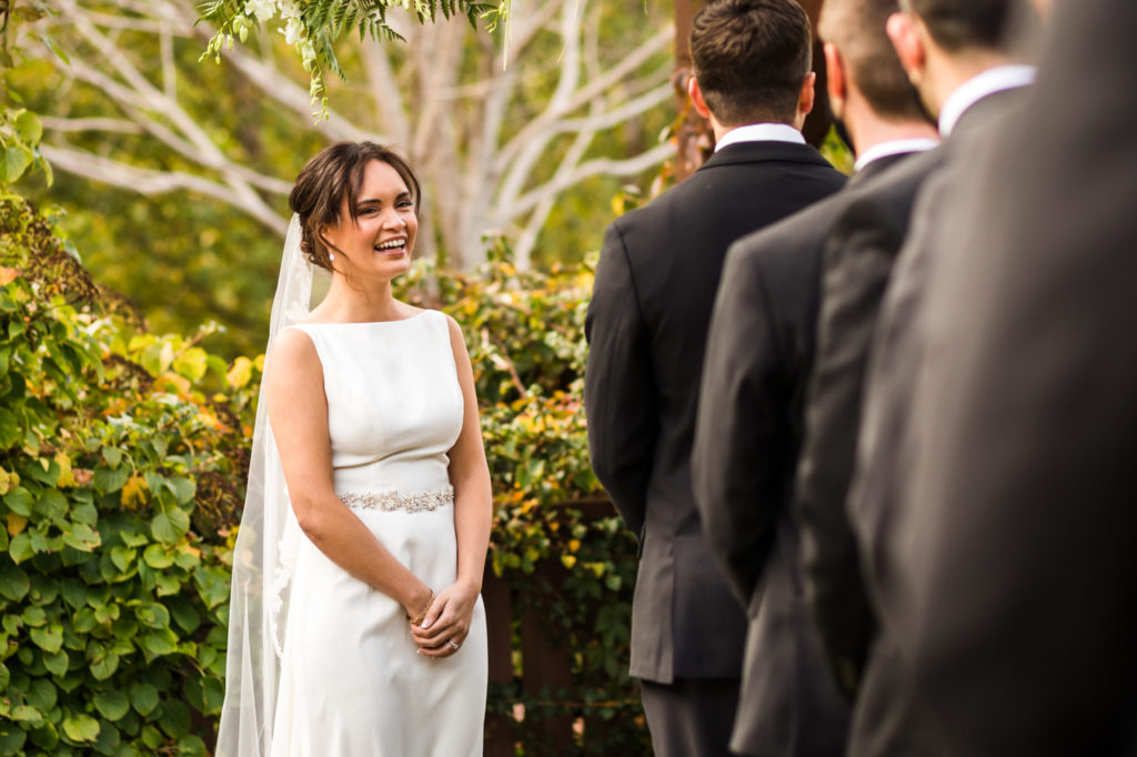 bride smiling at groom during wedding ceremony at house mountain inn wedding