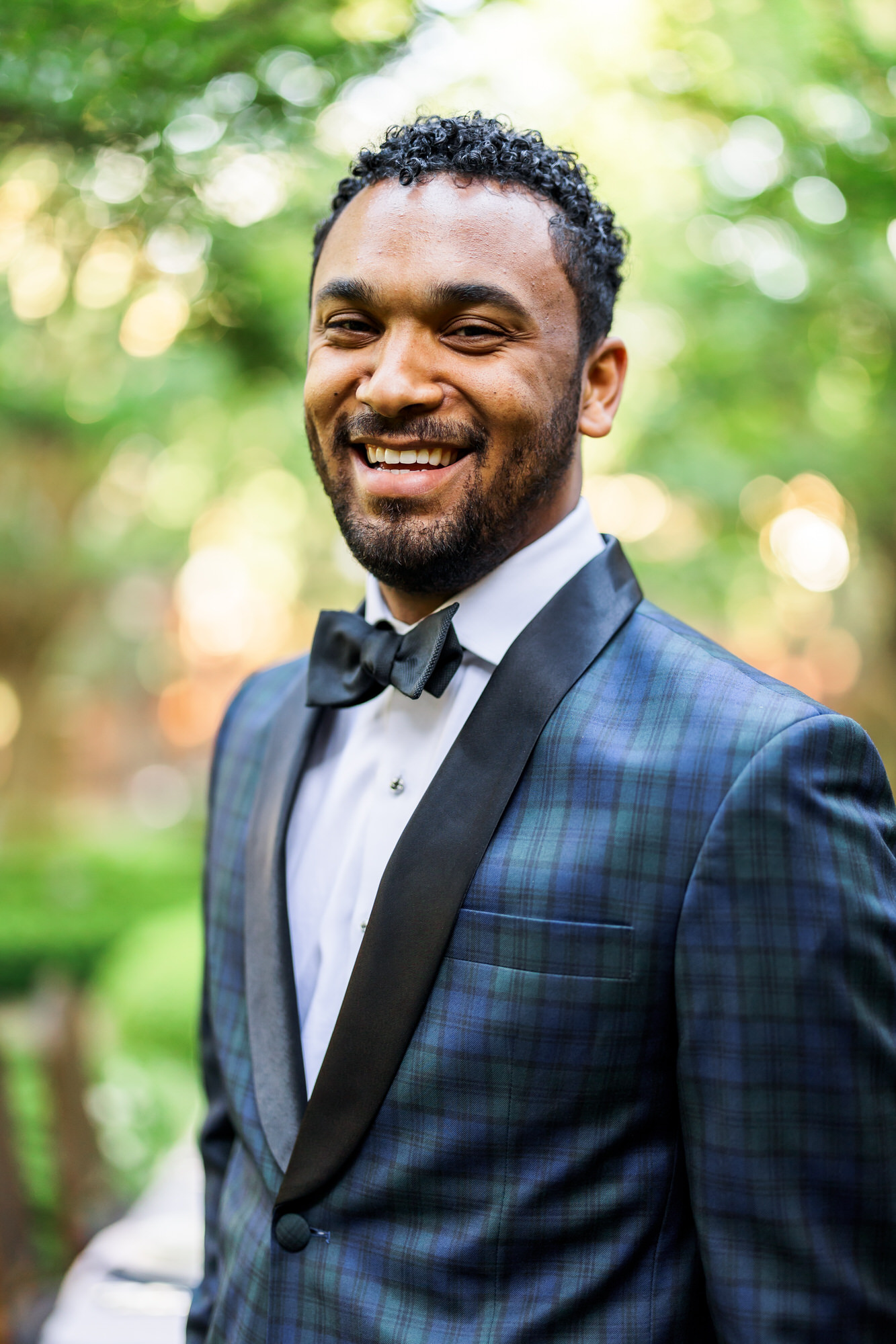 man smiling at camera navy suit and black bow tie