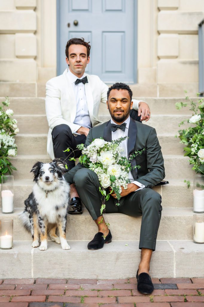 two grooms sitting on stairs after Bridgerton inspired wedding