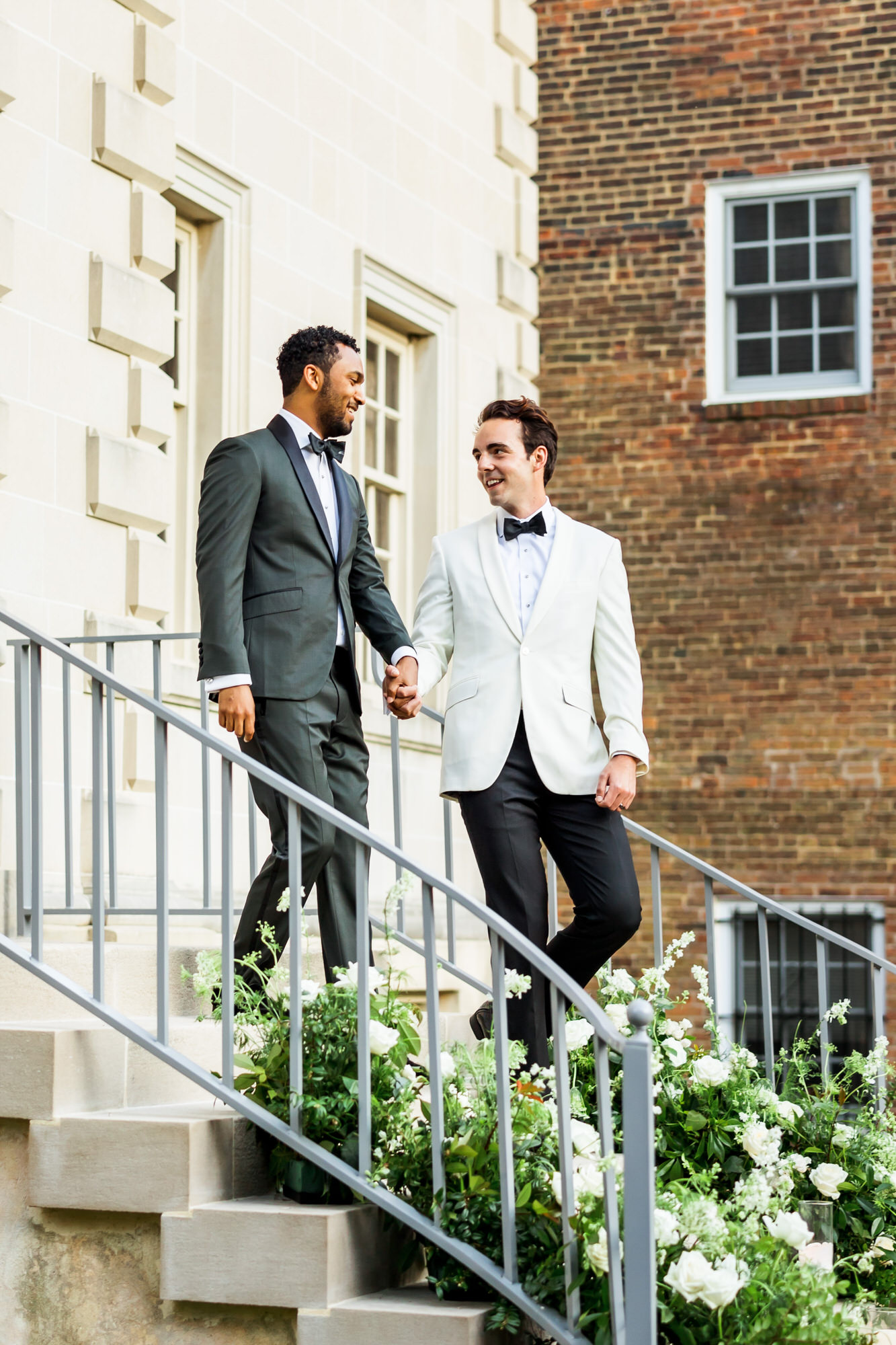 two grooms walking downstairs after bridgerton spring wedding inspiration