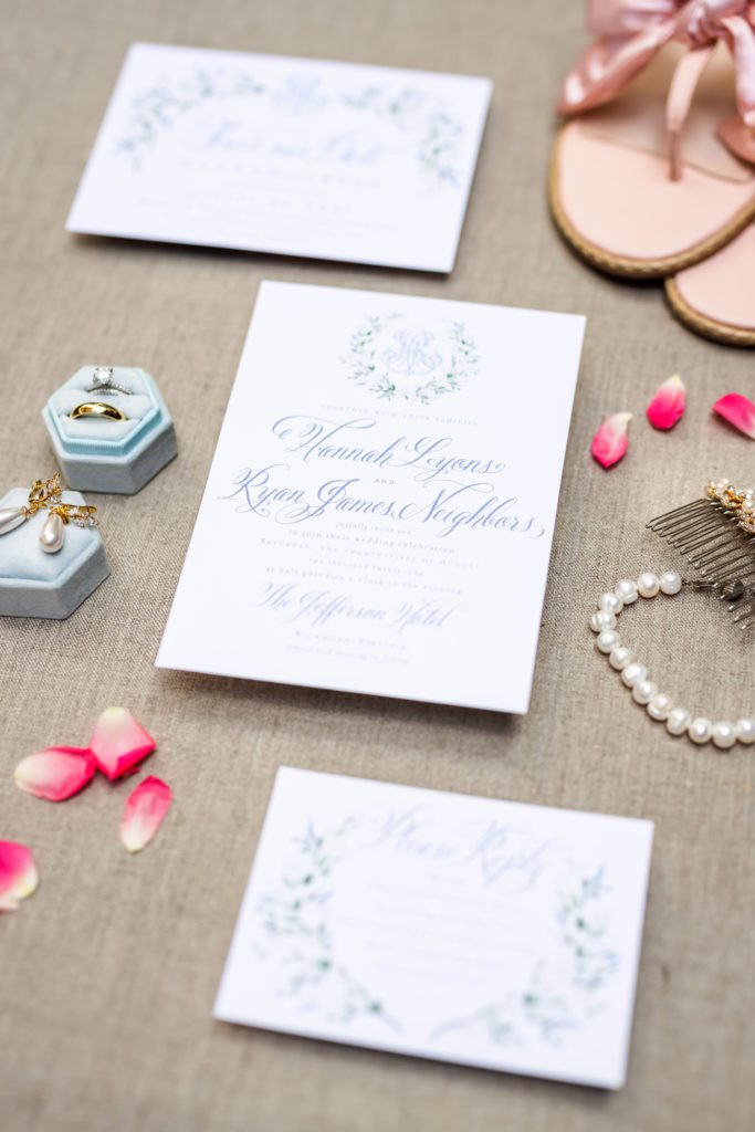 wedding day details with elegant white and navy wedding invitations and elements of pink throughout