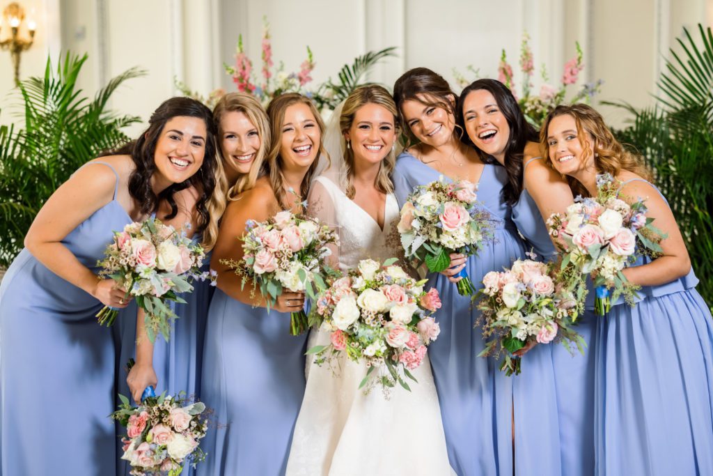 bride and bridesmaids wearing powder blue gowns during bridal portraits