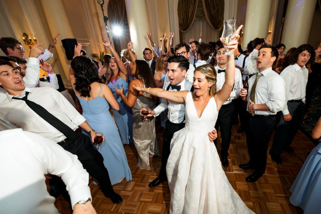 wedding couple celebrating on the dance floor with friends and family