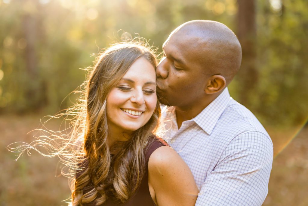 man kissing woman's cheek during fall charlottesville engagement photos at Montalto