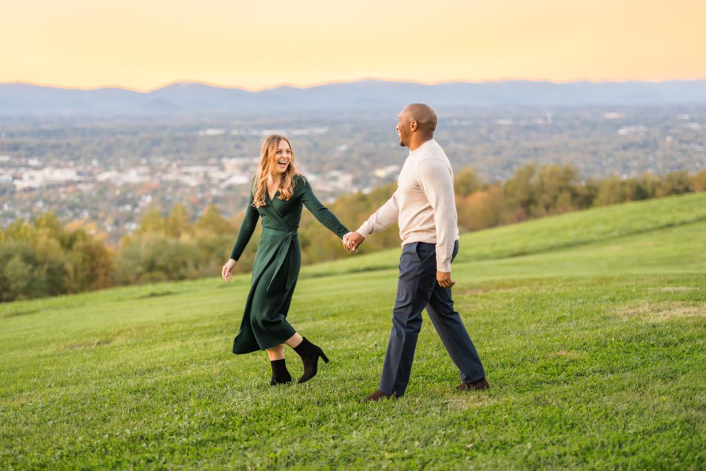man and woman walking hand in hand in green field