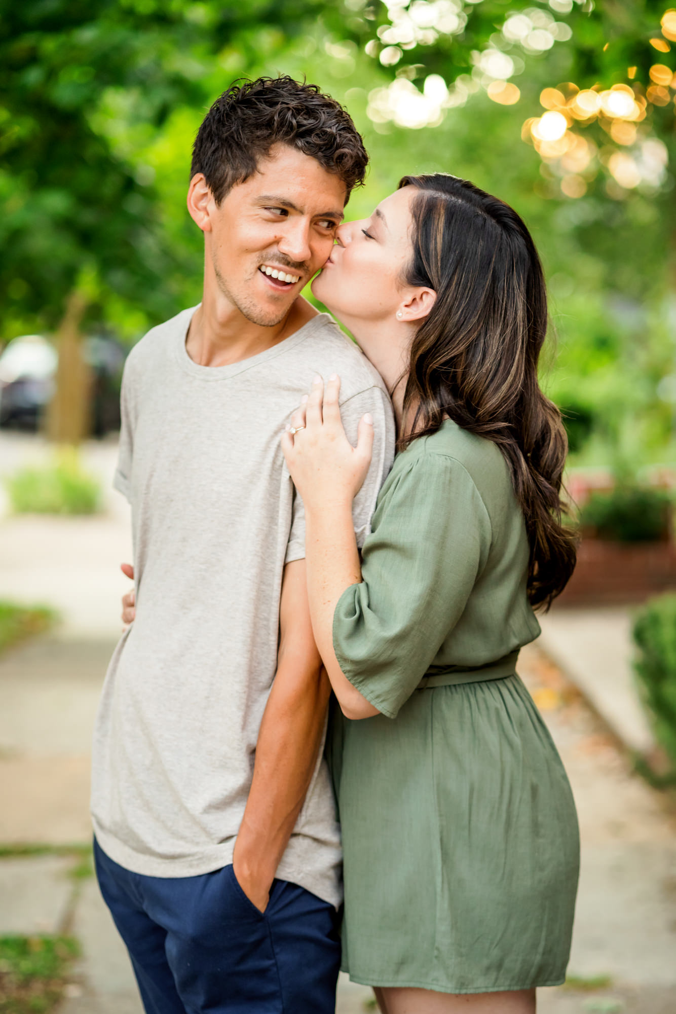 woman wearing green dress kissing man in oatmeal shirt during richmond engagement session