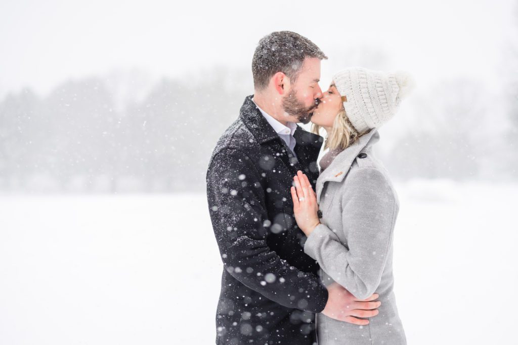 couple kissing in the snow at pen park