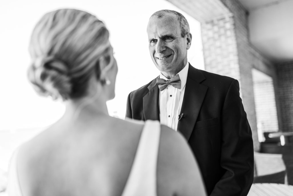 father smiling at daughter in wedding dress on wedding day