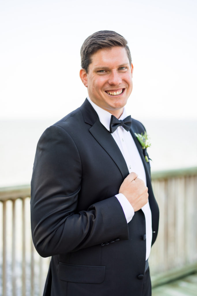 groom holding lapel during portraits