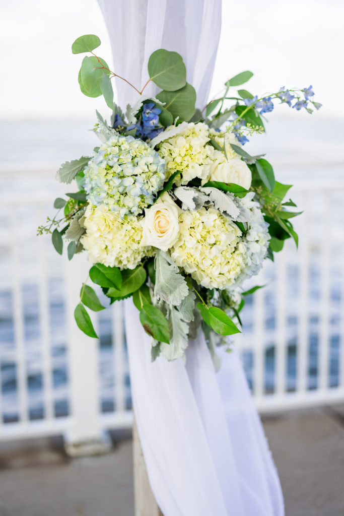 cream, white, green leaves, florals at wedding ceremony