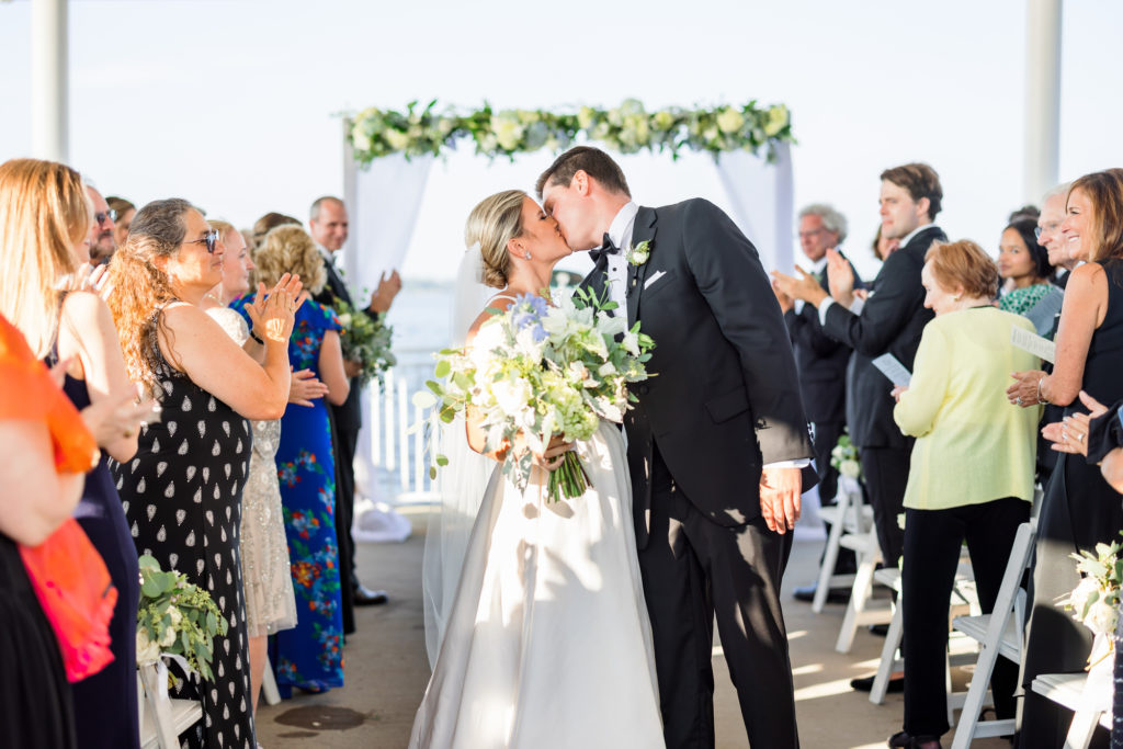 bride and groom kissing as they leave wedding ceremony