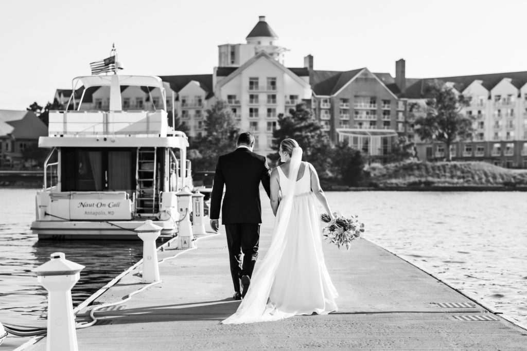 black and white image of couple walking off after wedding ceremony 