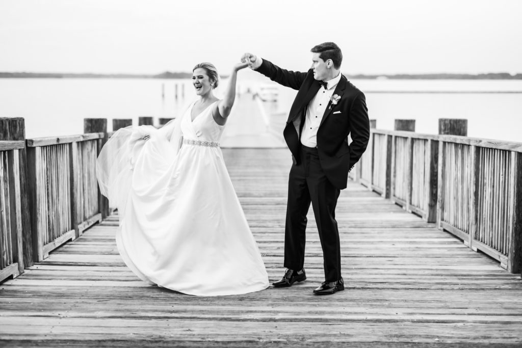 groom spinning bride on dock during bridal portraits after black tie eastern shore