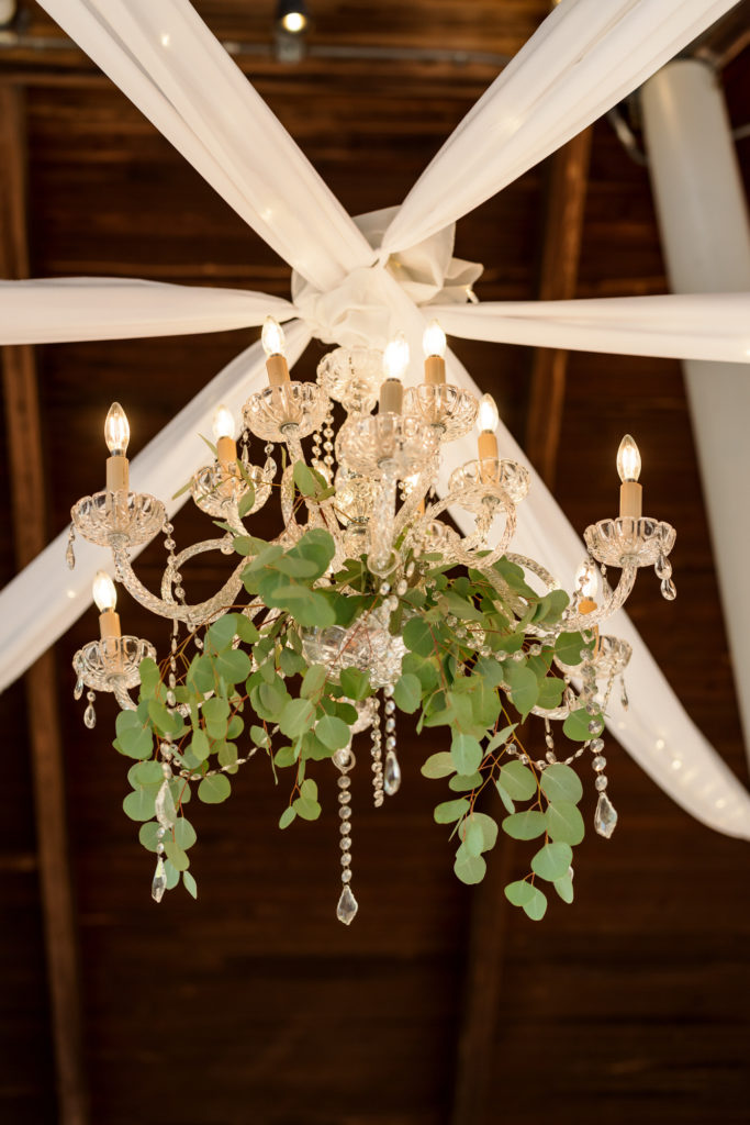 chandelier with greenery and white ribbon