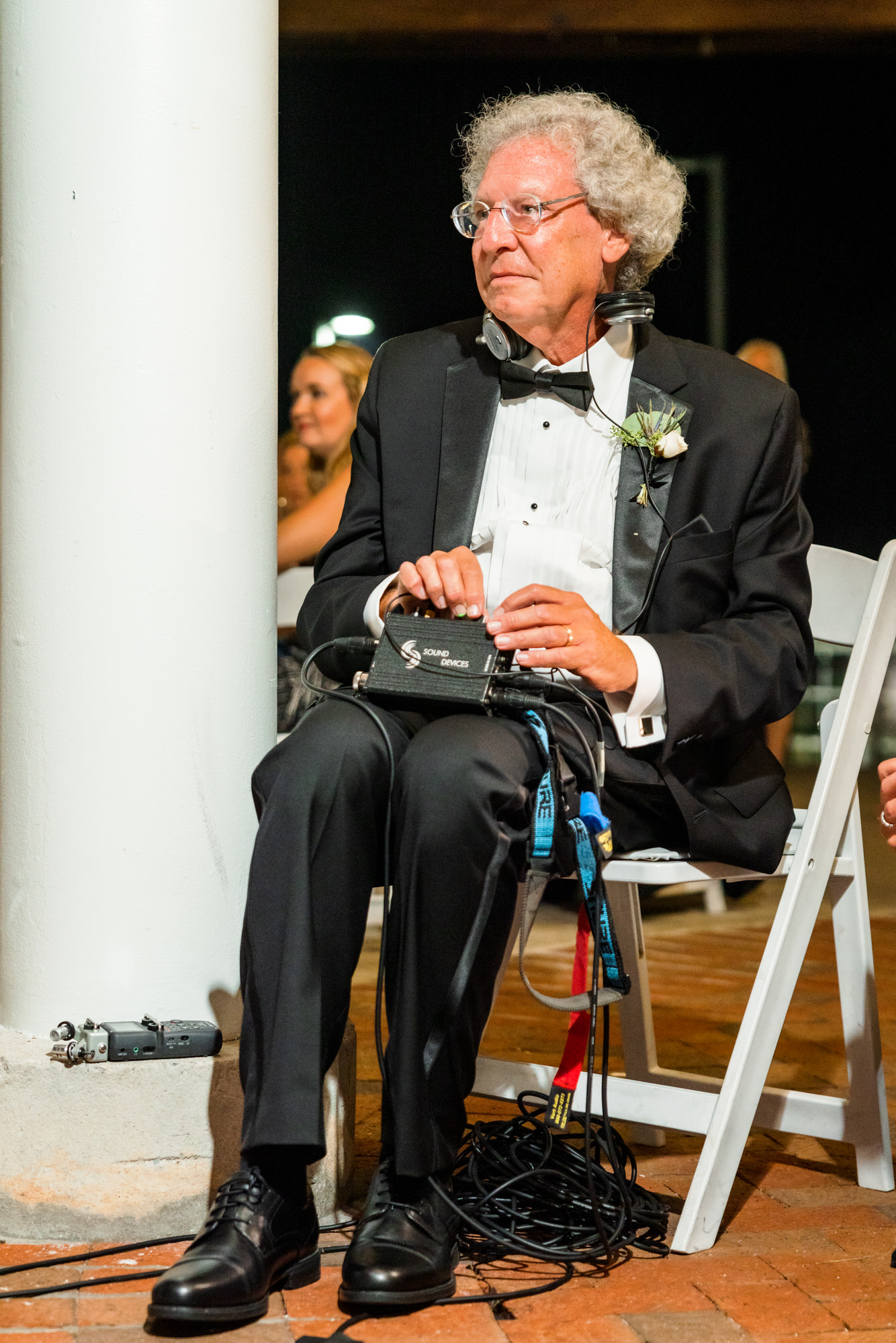older man sitting in chair during wedding reception