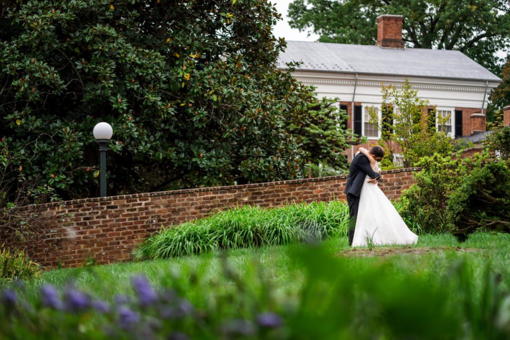bride and groom embracing on wedding day in UVA's garden