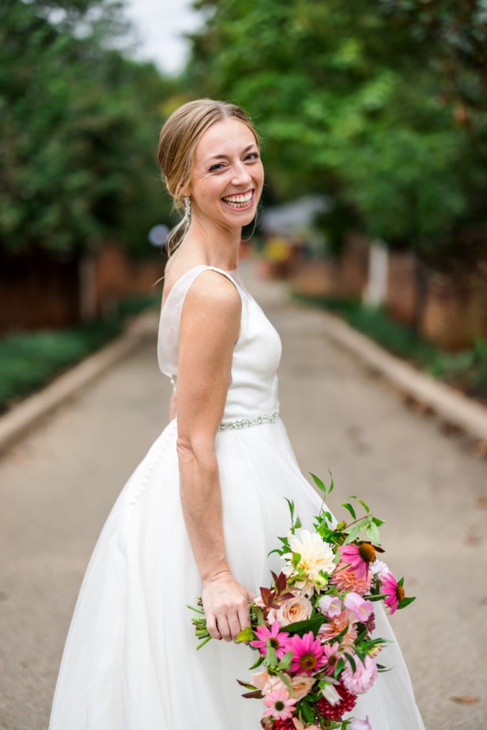 bride wearing v neck bridal gown with pink and red florals