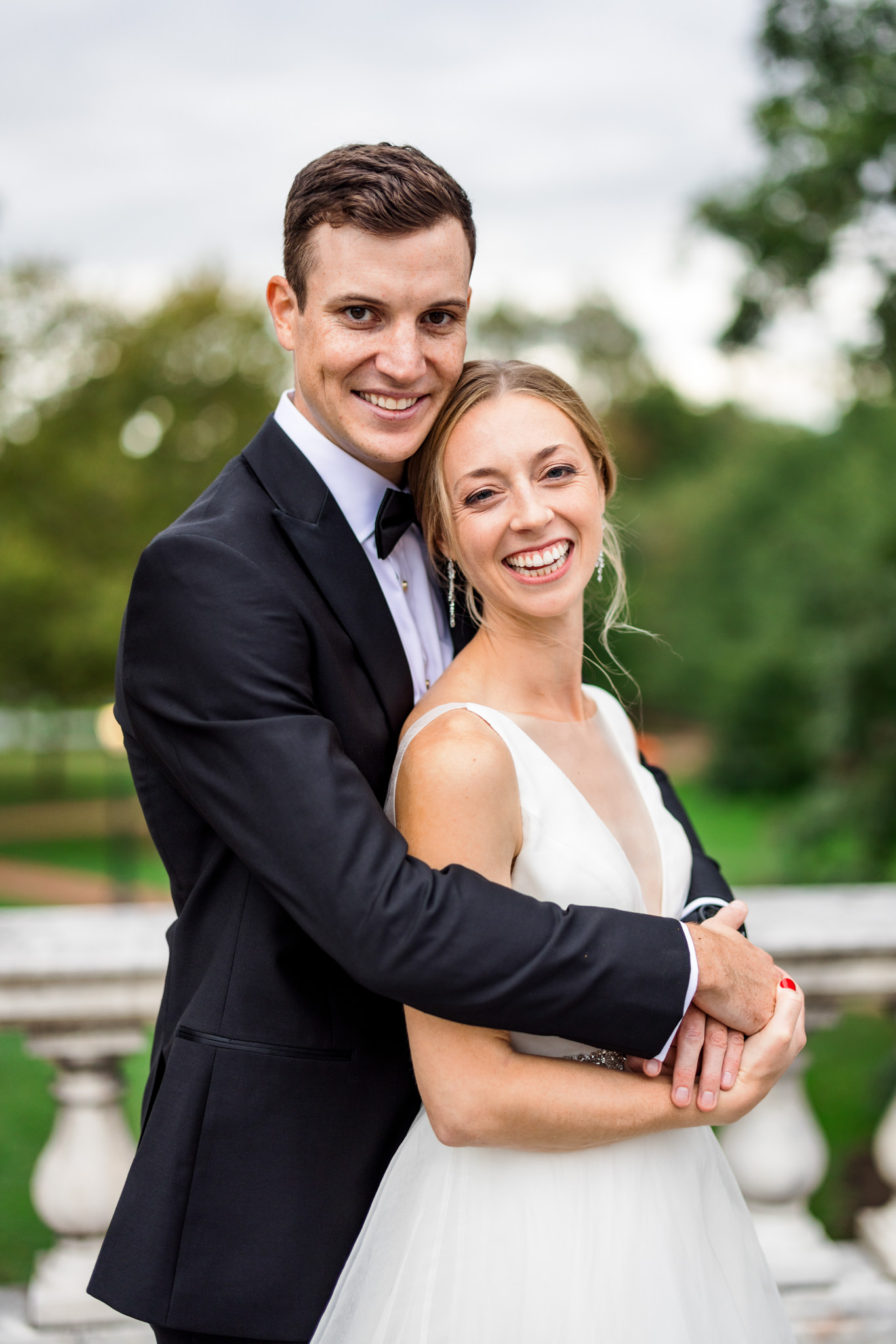 man wrapping arms around woman on wedding day