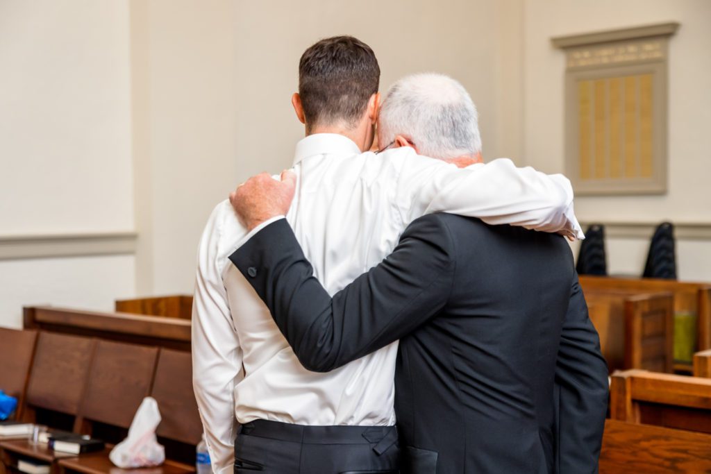 groom hugging father on wedding day
