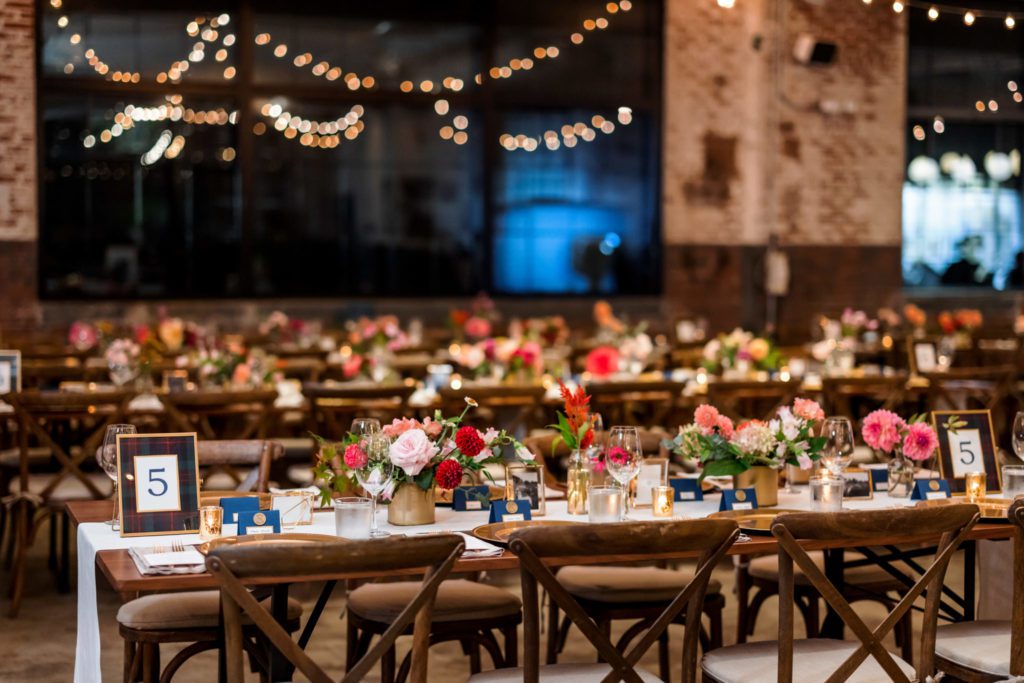wedding reception with wooden tables and rustic lighting at elegant wool factory wedding