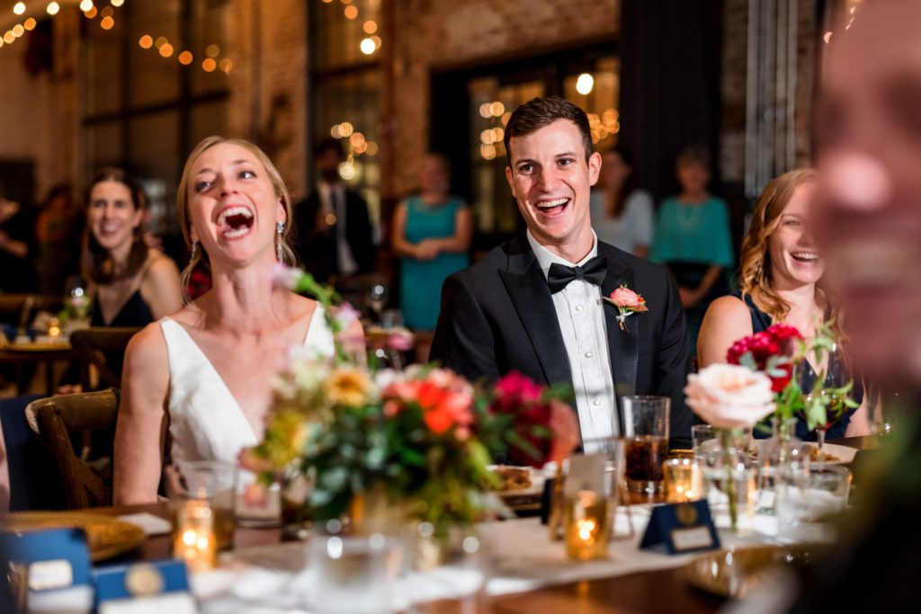 wedding couple laughing during speeches at wedding reception