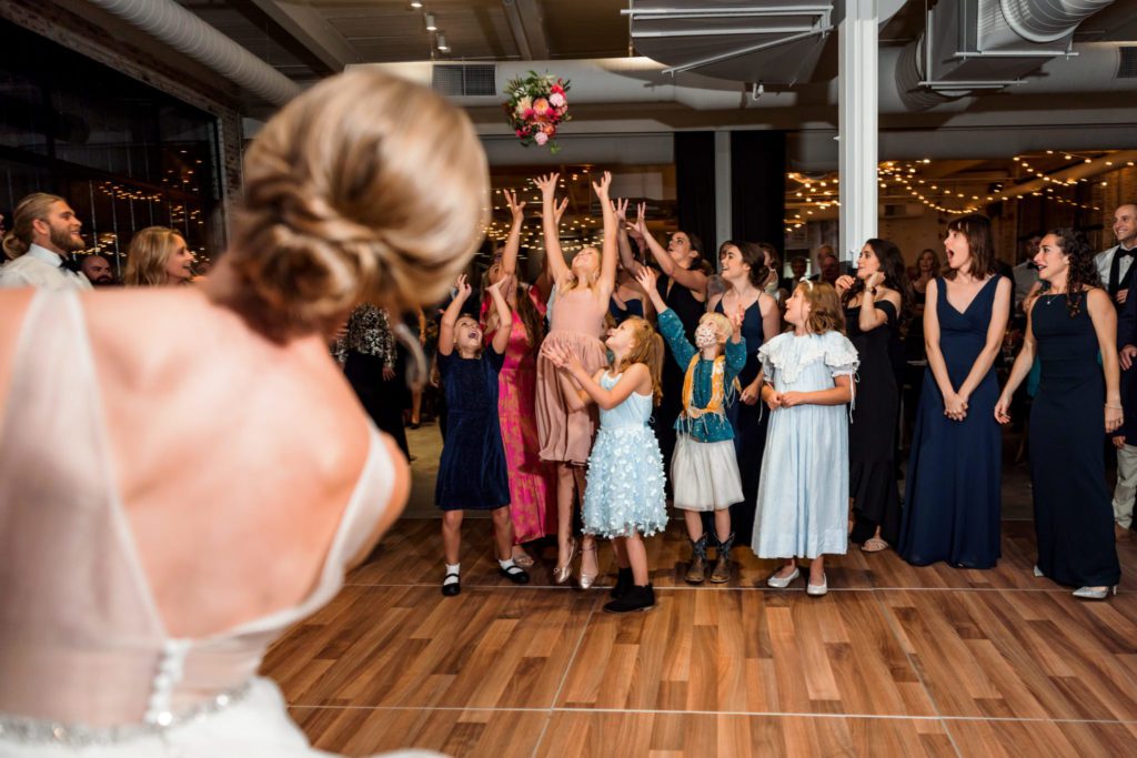 bride throwing bouquet during wool factory wedding reception