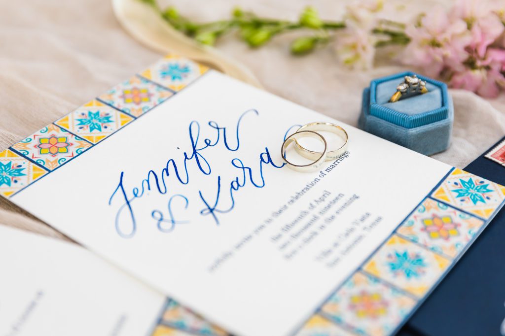 spanish inspired wedding invitation with wedding rings on top