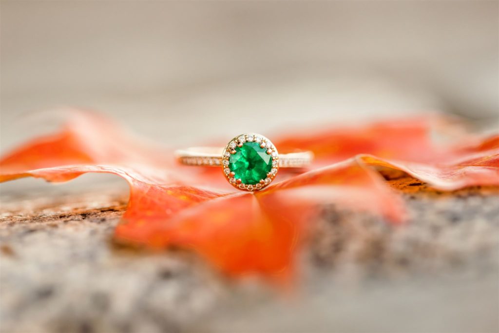 Emerald engagement ring detail shot on red maple leaf during fall Charlottesville engagement session