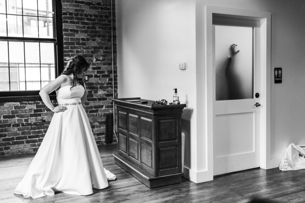 bride waiting on groom getting ready before intimate fall wool factory wedding
