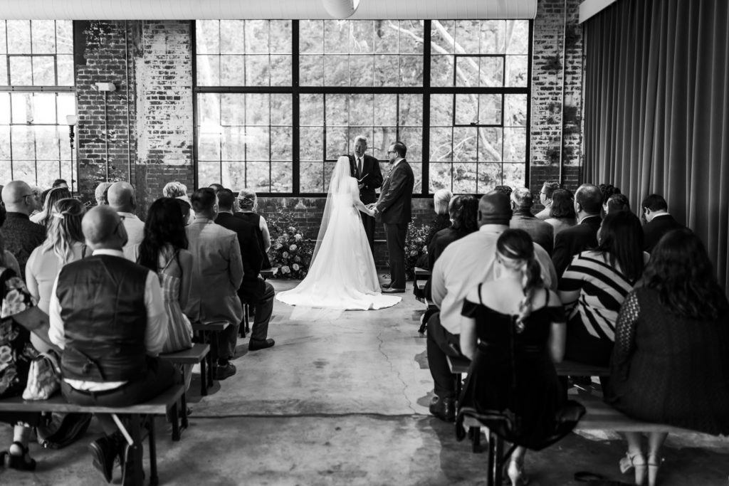 wedding couple holding hands during wedding ceremony at Wool Factory