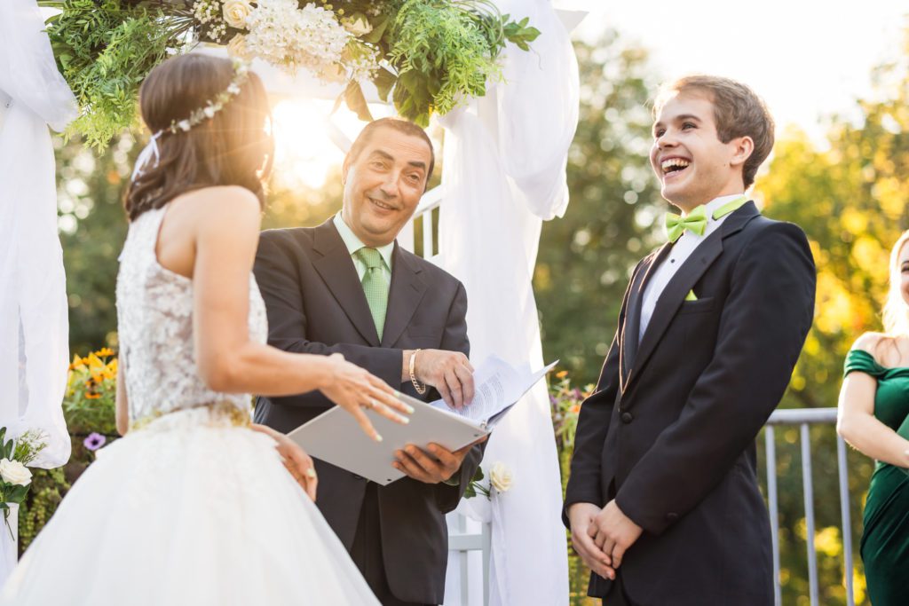 officiant smiling and laughing during bride's vows