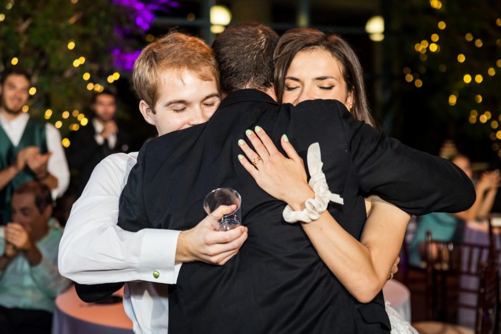 wedding couple hugging friends at reception
