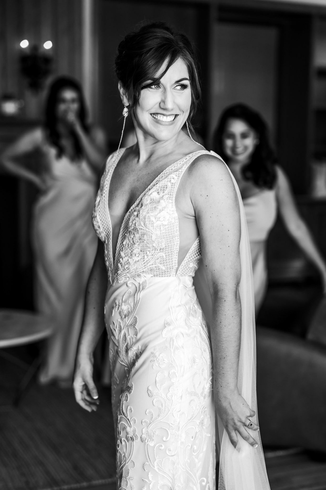 bride wearing v-neck fitted wedding gown with lace smiling 