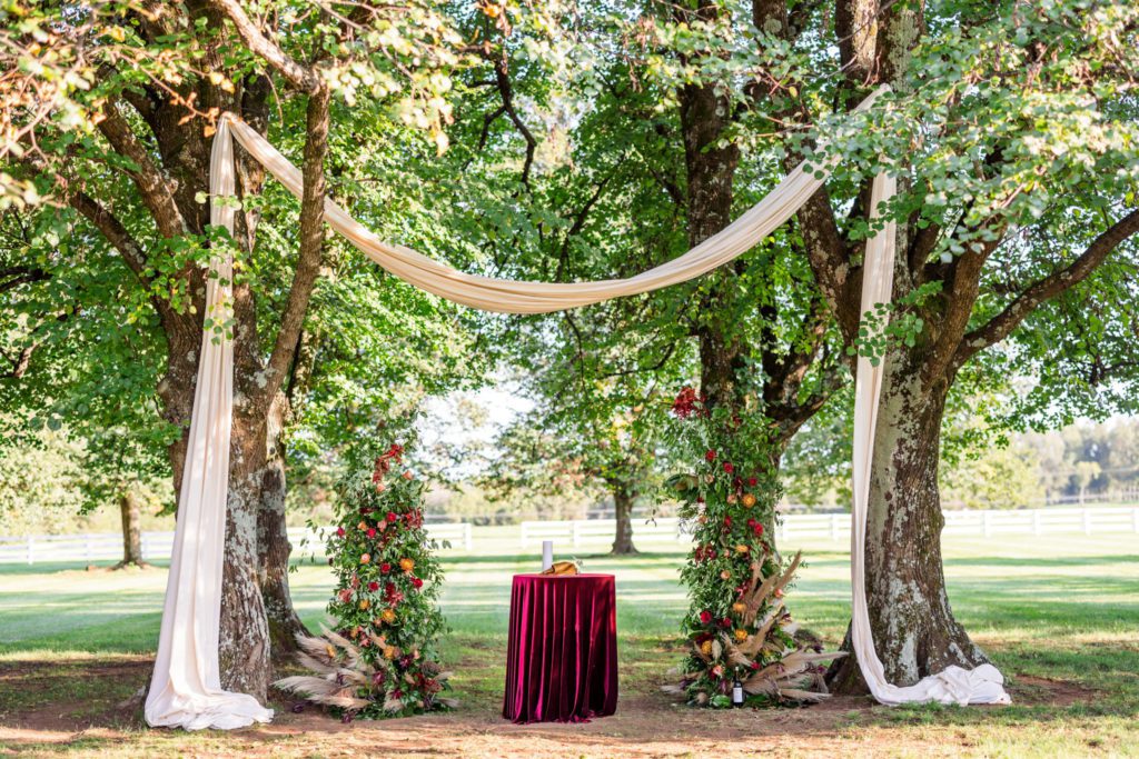 outdoor chic forested tree wedding ceremony with silk and alter