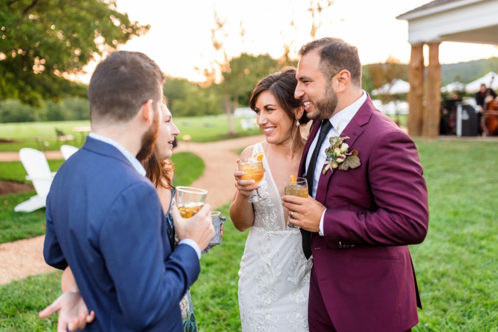 newly married couple drinking and celebrating with wedding guests