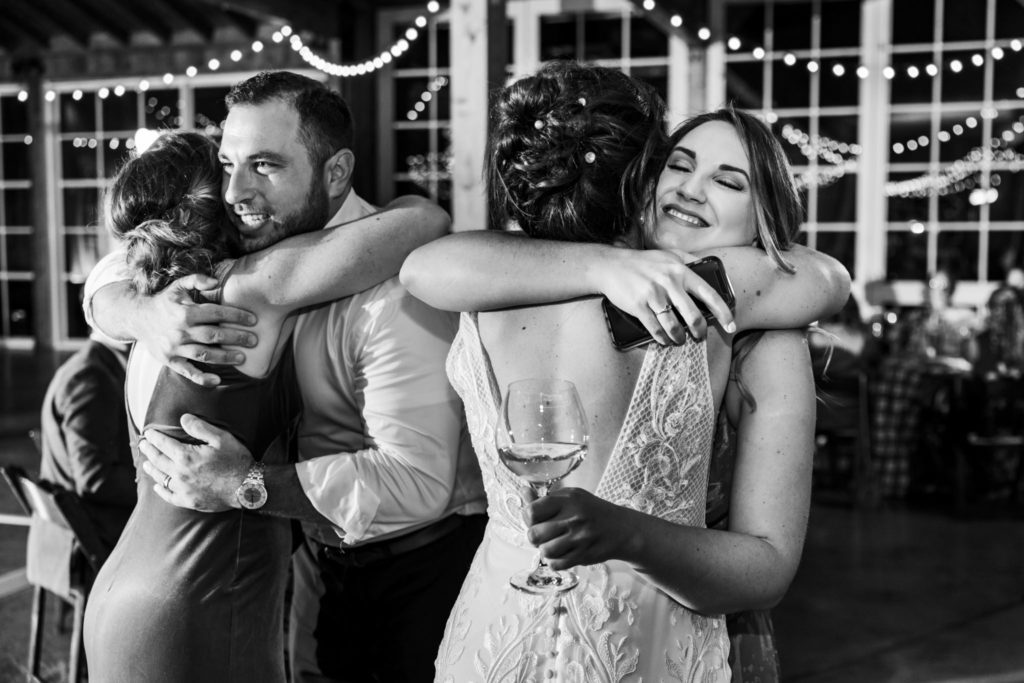 bride and groom hugging guests during wedding reception