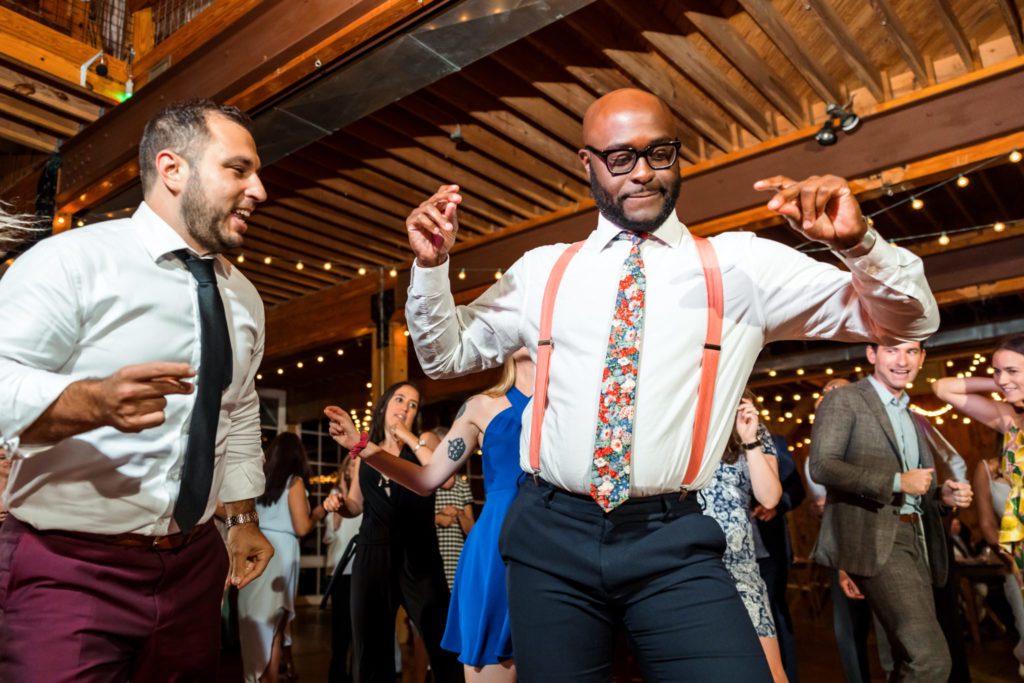 groom dancing with friends and family at reception
