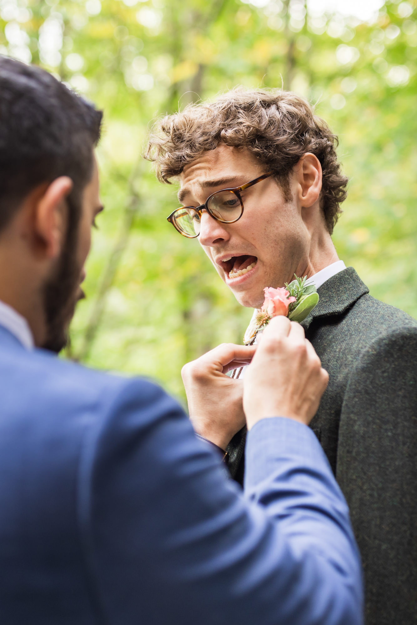 groom getting boutonniere on colorful fall boho wedding day 