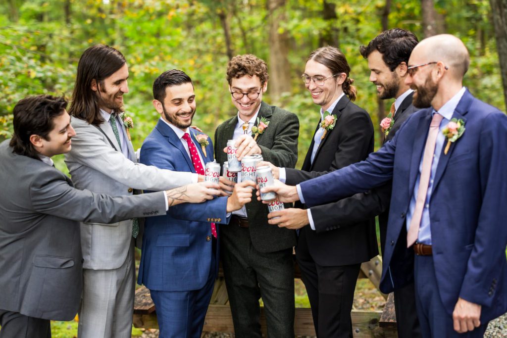 groom toasting with groomsmen before colorful fall boho wedding