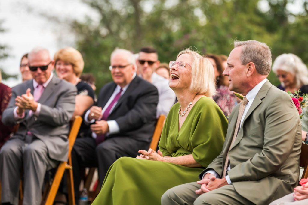wedding guests laughing and smiling during ceremony