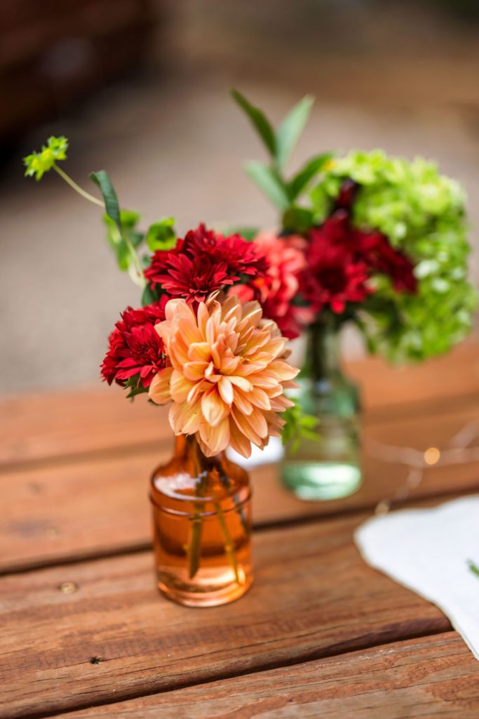 minimalist centerpieces with colorful flowers in small vases 