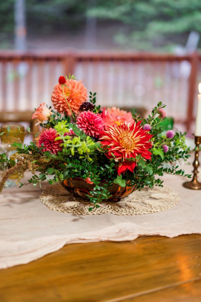floral centerpiece with colorful florals sitting on wooden table