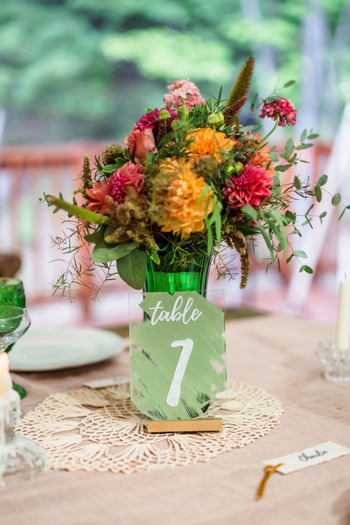larger vase of colorful flowers with acrylic table number