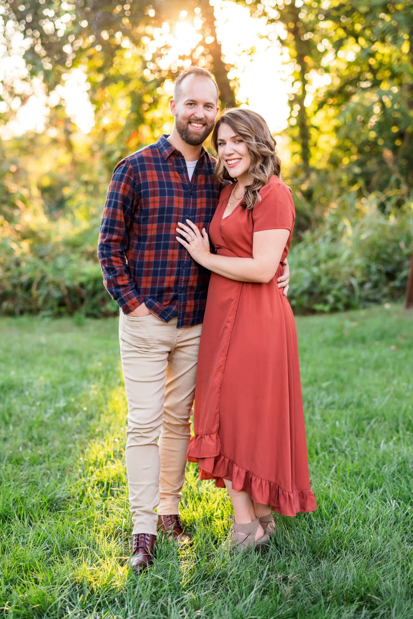 woman wearing rust orange dress with fiance wearing plaid shirt during outdoor engagements