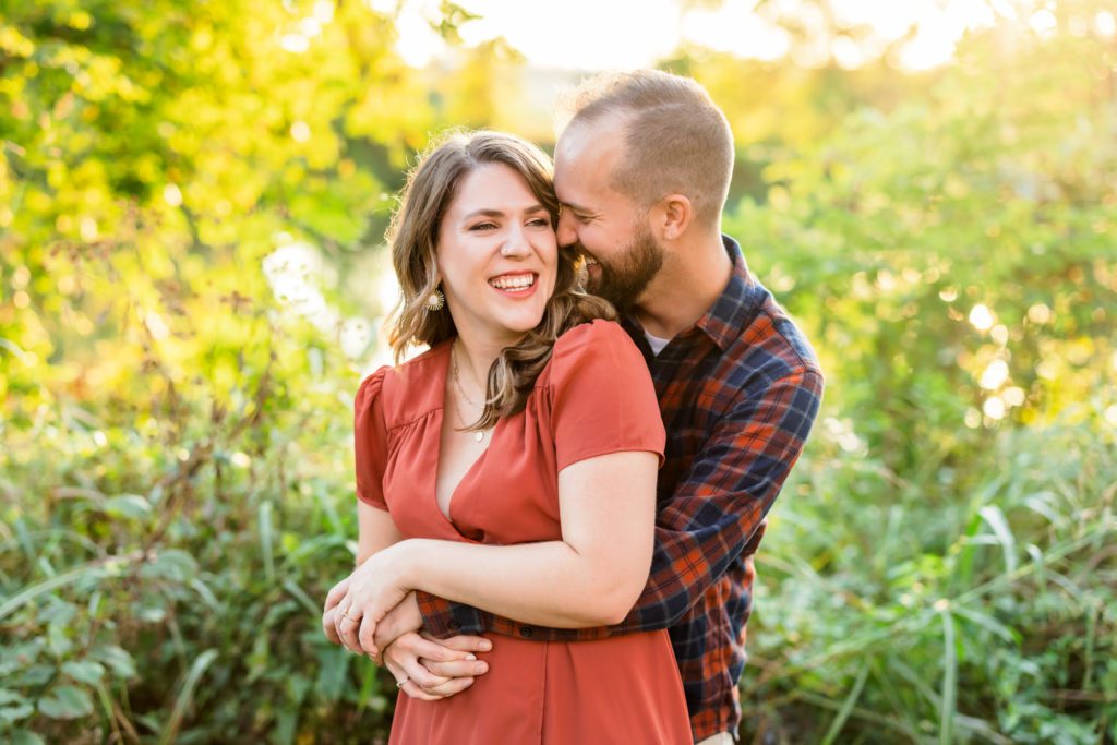 engaged couple embracing during fall canal walk engagement session