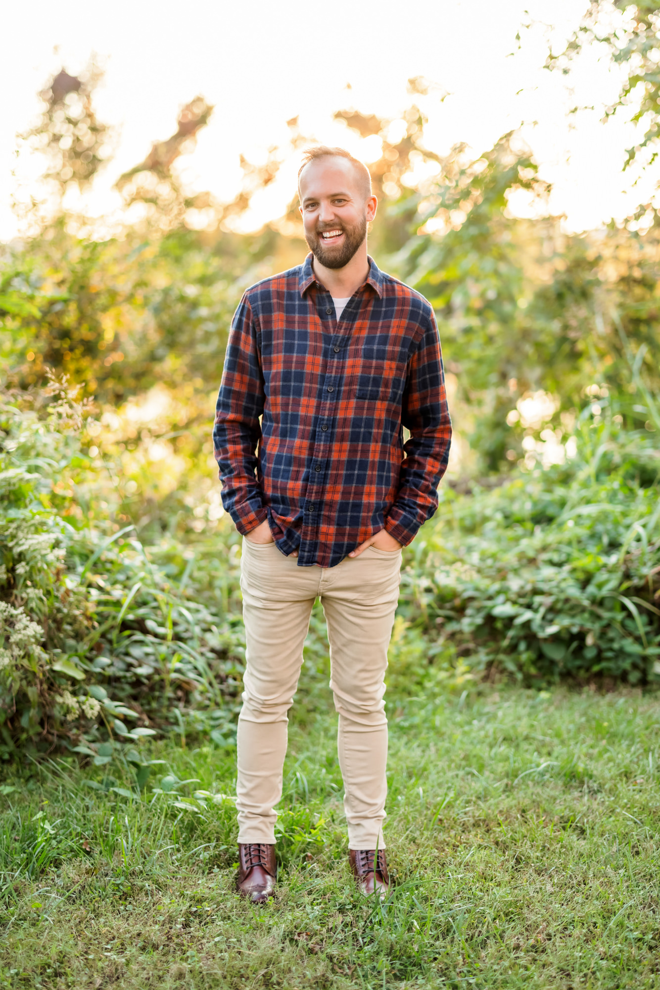 man wearing navy and rust flannel during fall canal walk engagement session